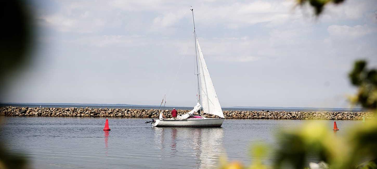 Lystsejler båd sejler ind i Bogense Marina i sommertid