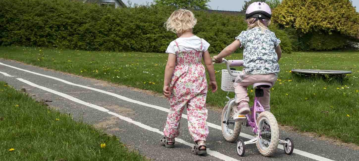 En lille pige går og en lille pige cykler sammen på den blå kløversti i Søndersø