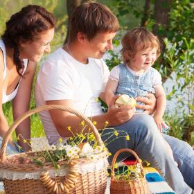 Mor, far og barn på picnic i sommertid