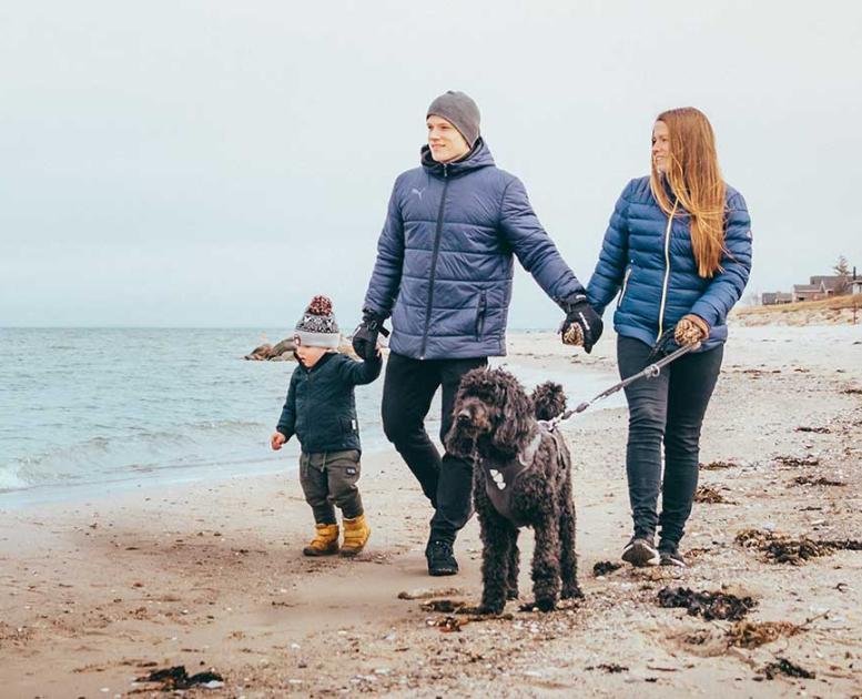 Mor, far, barn og hund går tur på Fuglsang Strand i vintertid